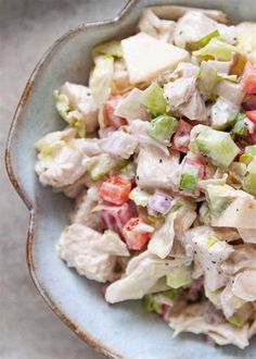 a bowl filled with chicken salad on top of a table