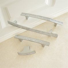 three silver handles on a white sink in a room with beige flooring and walls