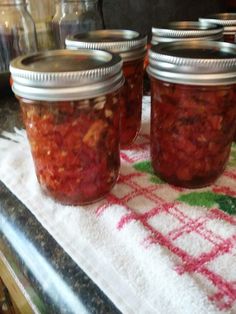 three jars filled with food sitting on top of a table