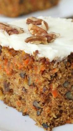 a piece of carrot cake on a plate with a fork next to it and a bite taken out