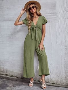 Our Tommy Bow Jumpsuit comes in a gorgeous army green tone in a relaxed fit. The low v neckline and front breast tie cinches in the figure. This comfortable jumpsuit is a must-have for every summer wardrobe. Size Guide: Lisa S is 5'6"tall, and has a 33.6"bust,24.2"waist,38.1"hips. She is wearing a S / US4 / AU8. This jumpsuit is true to size. Material: 65% Linen, 35% Viscose Feature: Wide-leg pants. Relaxed fit. Low V neckline. Tie bow on front. Maternity friendly. Care Instructions: Machine was Green V-neck Casual Jumpsuits And Rompers, Casual Green Jumpsuits And Rompers With Tie Waist, Casual Olive Jumpsuits And Rompers For Spring, Bow Jumpsuit, Lisa S, Cropped Jumpsuit, Knit Jumpsuit, Casual Rompers, Woman Weaving