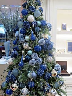 a blue christmas tree with ornaments on it