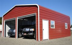 two cars are parked in front of a red metal building with white trim on it