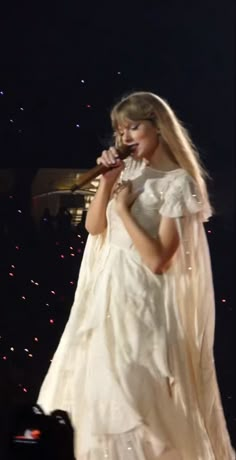 a woman in a white dress holding a microphone