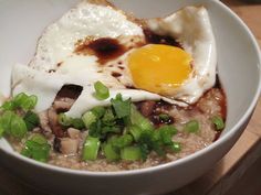 a white bowl filled with rice and topped with an egg