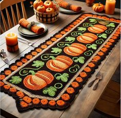 a crocheted table runner with pumpkins and leaves on it, along with candles