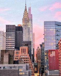 an image of a cityscape with skyscrapers in the foreground and pink clouds in the background