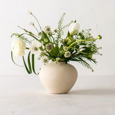 a vase filled with white flowers on top of a table