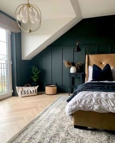 a bedroom with dark green walls, white bedding and wooden floors is pictured in this image