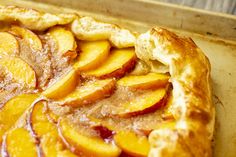 a close up of a pie with peaches on it in a baking pan, ready to be eaten