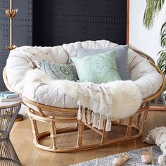 a wicker rocking chair with pillows on it