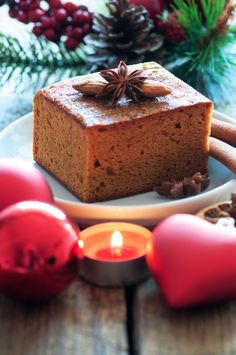 a piece of cake sitting on top of a white plate next to candles and decorations