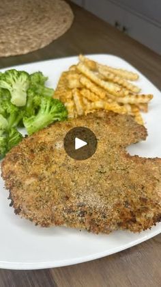 a white plate topped with meat, fries and broccoli