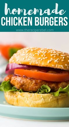 a chicken burger with lettuce, tomato and onion on a bun that is sitting on a plate