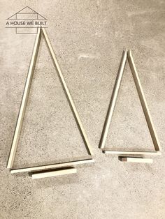 two metal triangles sitting on top of a cement floor