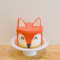 a cake that has been decorated to look like a fox on top of a plate