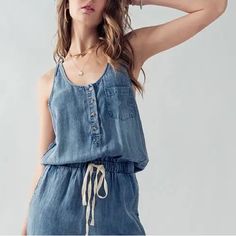 Tencel Drawstring Sleeveless Jumpsuit Bestseller With Front Buttons And A Tie For Tightening The Waist, Elastic Jogger Style Bottoms 100% Tencel Summer Cami Jumpsuits And Rompers, Casual Cami Jumpsuits And Rompers For Summer, Casual Sleeveless Camisole For Loungewear, Chic Sleeveless Cotton Denim Jumpsuit, Summer Sleeveless Jumpsuits And Rompers For Loungewear, Casual Cami Jumpsuits And Rompers For Beach, Casual Cami Jumpsuits And Rompers For Vacation, Casual Cami Jumpsuit For Beach, Blue Sleeveless Cotton Denim Jumpsuit