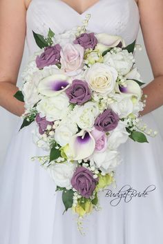 a bride holding a bouquet of white and purple flowers