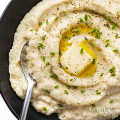 mashed potatoes with butter and chives in a black bowl