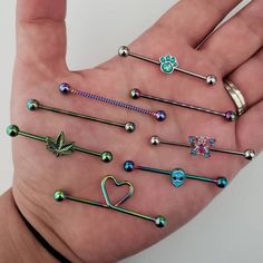 a person's hand holding several different types of piercings