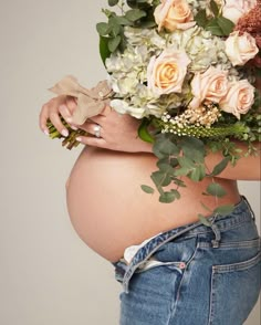 a pregnant woman with flowers in her belly and jeans on the bottom of her stomach