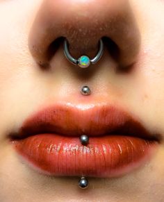 a woman's nose with two piercings attached to the top of her lip