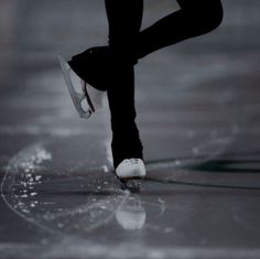 a person wearing white shoes and black pants is walking on the street with their feet in the air