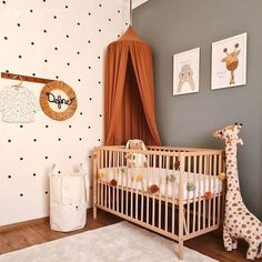 a baby's room with polka dot wallpaper and wooden crib