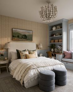 a bedroom with a large bed sitting next to a window filled with lots of pillows