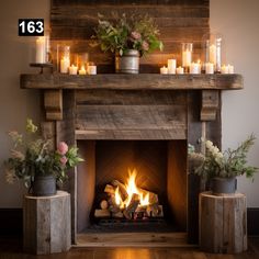 a fireplace with candles and flowers on it