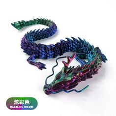 two colorful dragon figurines sitting next to each other on a white surface with chinese writing