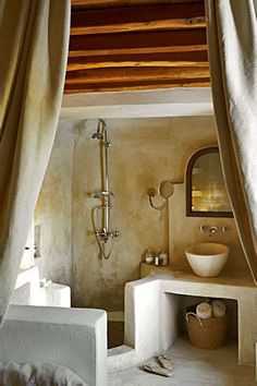 a bath room with a toilet a sink and a shower head mounted to the wall