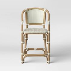 a chair made out of bamboo and wicker with a white seat pad on the back