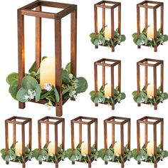 a set of six wooden lanterns with flowers and greenery in them