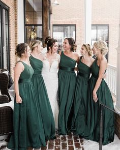 the bride and her bridesmaids are laughing together in their green gowns at this winter wedding