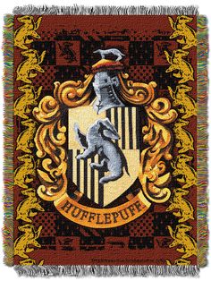 the hogwarts crest tapestry is shown on a red and yellow blanket with gold trim