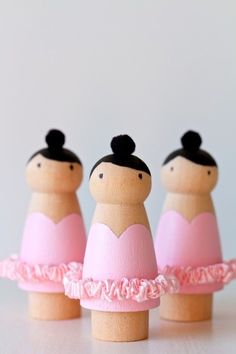 three little wooden dolls in pink dresses