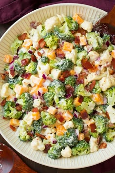 a bowl filled with broccoli, cauliflower and bacon