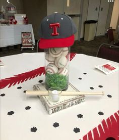 a baseball cap is sitting on top of a stack of baseballs in a jar