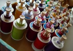 many spools of thread are lined up on a table next to each other