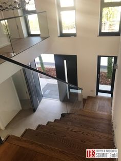 an empty staircase with glass railings leading up to the second floor