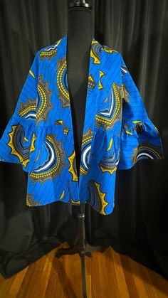 An elegant blue mustard with black, gray, and white mid-length kimono accents is the perfect African print for any event. You can style this kimono with a dress, skirt, or dress pants or dress down with denim or leggings. Why not add this kimono to your wardrobe? Casual Blue Cotton Kimono, Spring Workwear Kimono With Kimono Sleeves, Blue Outerwear With Kimono Sleeves For Spring, Blue Printed Outerwear For Spring, Blue Stretch Cotton Outerwear, Spring Workwear Kimono, Fitted Casual Cotton Kimono, Casual Fitted Cotton Kimono, Fitted Blue Bohemian Kimono