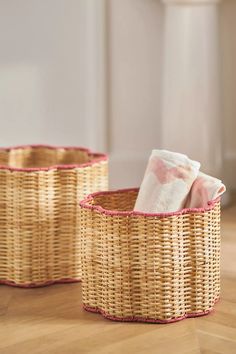 two wicker baskets sitting on top of a wooden floor