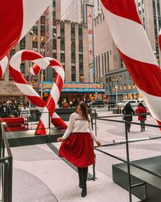 a woman standing in front of giant candy canes