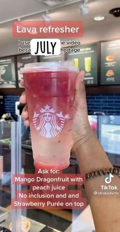 a person holding up a pink starbucks drink