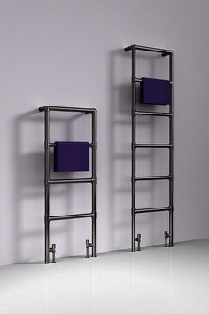 an empty room with two metal shelves and purple towels