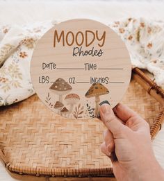 a person holding up a wooden sign that says moody phodee and mushrooms