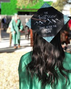 a woman wearing a graduation cap that says the best view comes after the moment