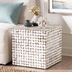 a white and brown box sitting on top of a wooden floor next to a couch