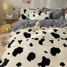 a black and white cow print comforter on a bed